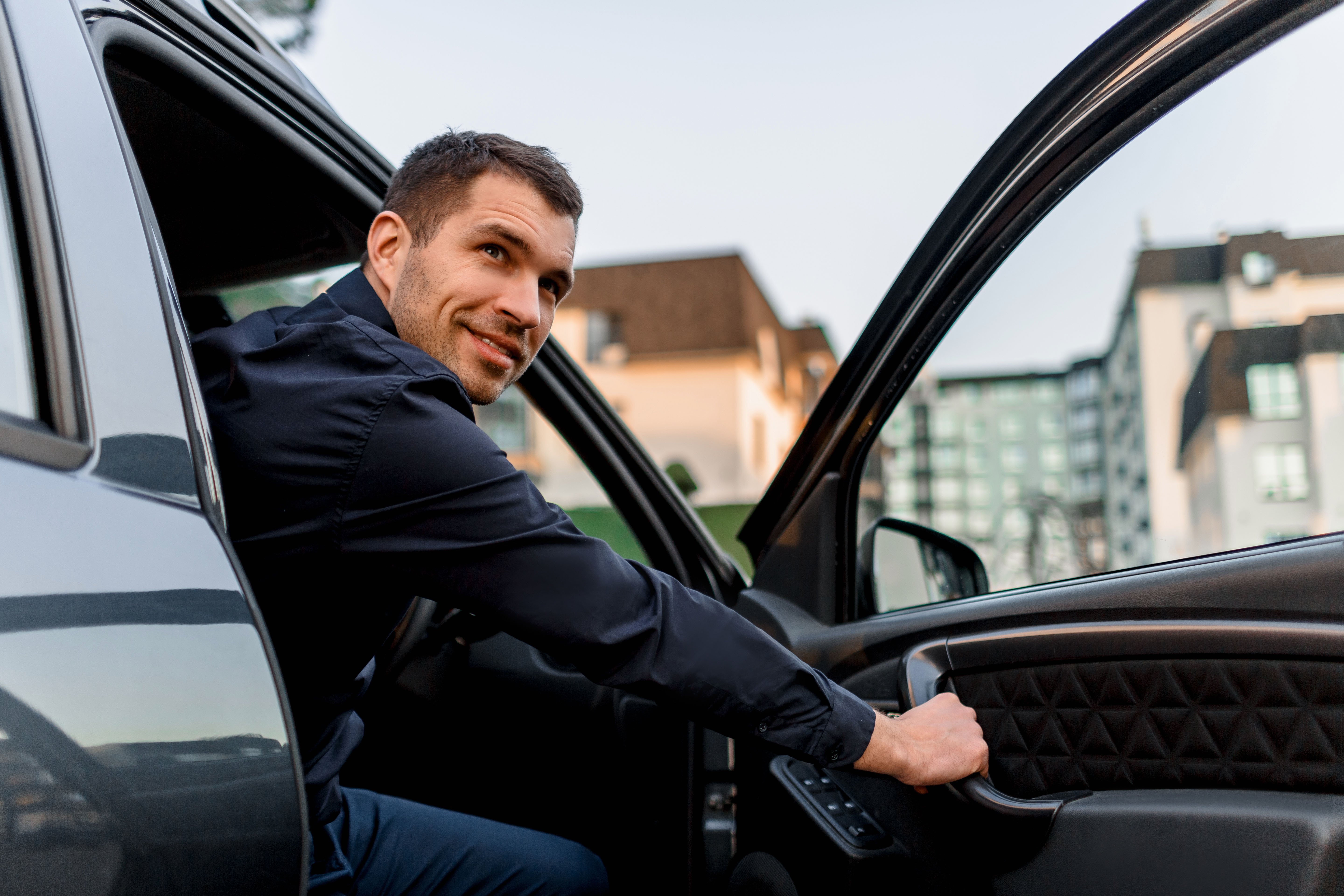 Taxi driver exiting through the driver-side door of his car