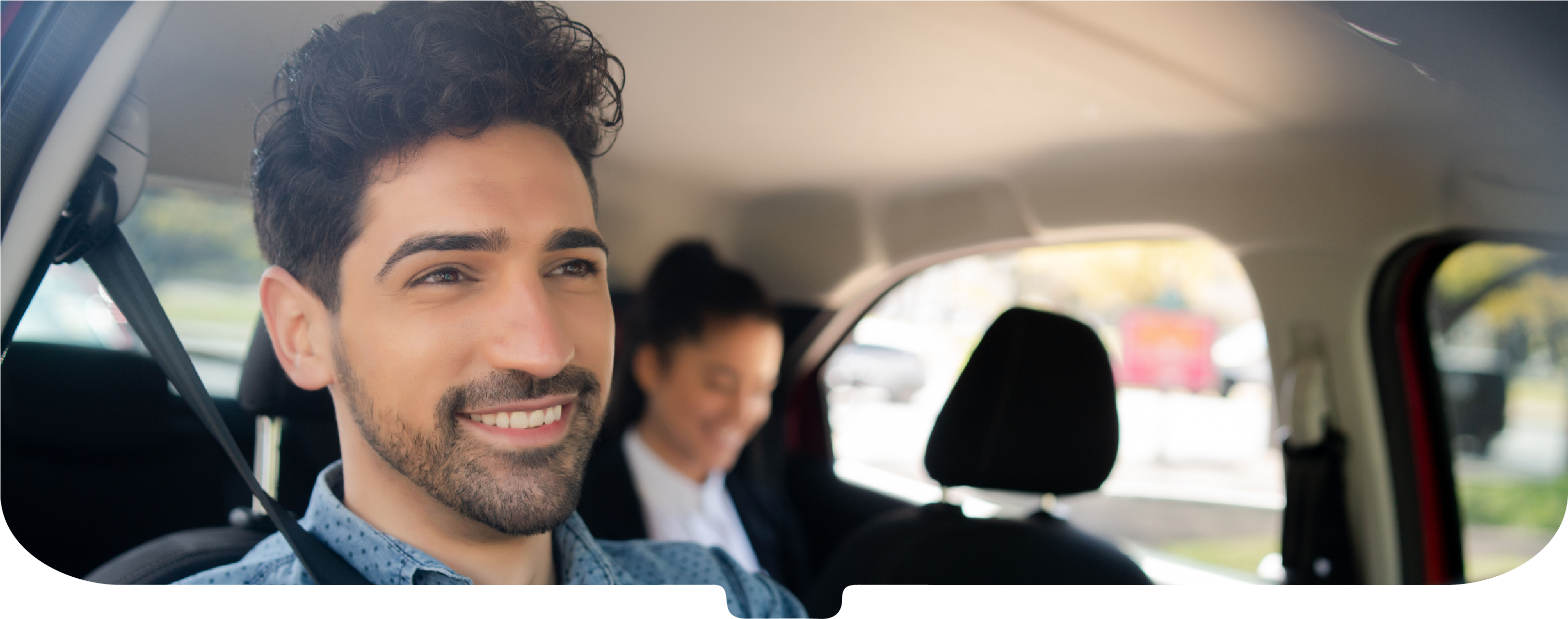 Smiling driver with a smartly dressed passenger on the backseat