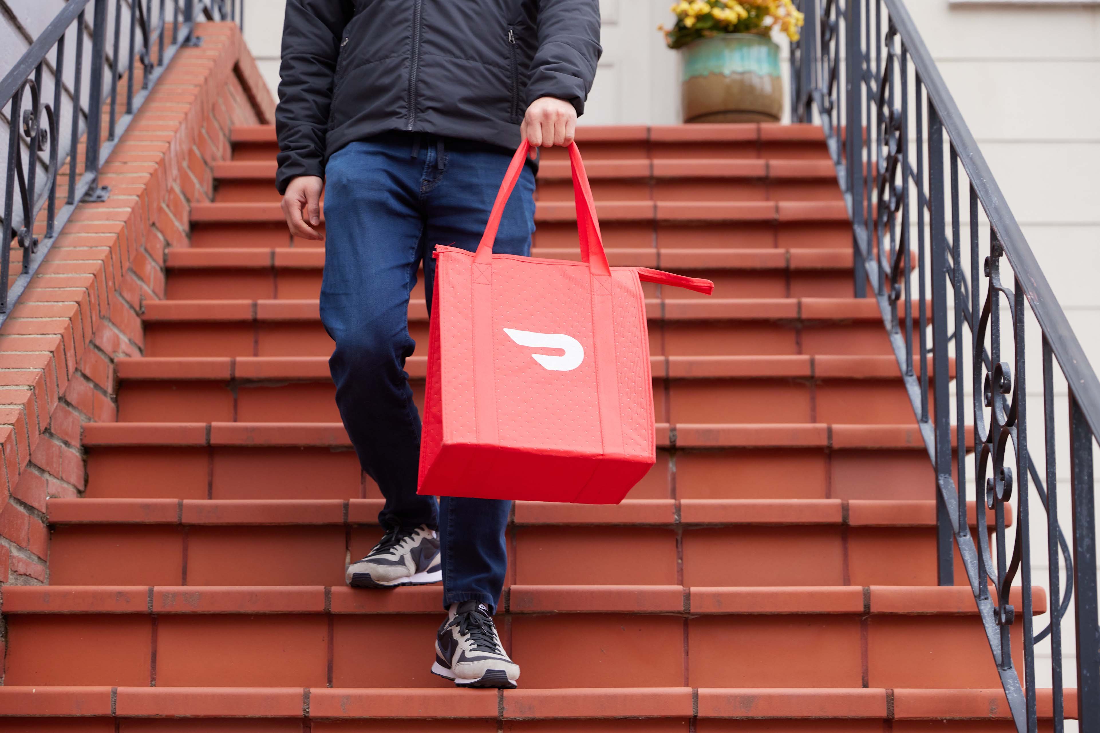Doordash delivery person walking down steps with delivery bag