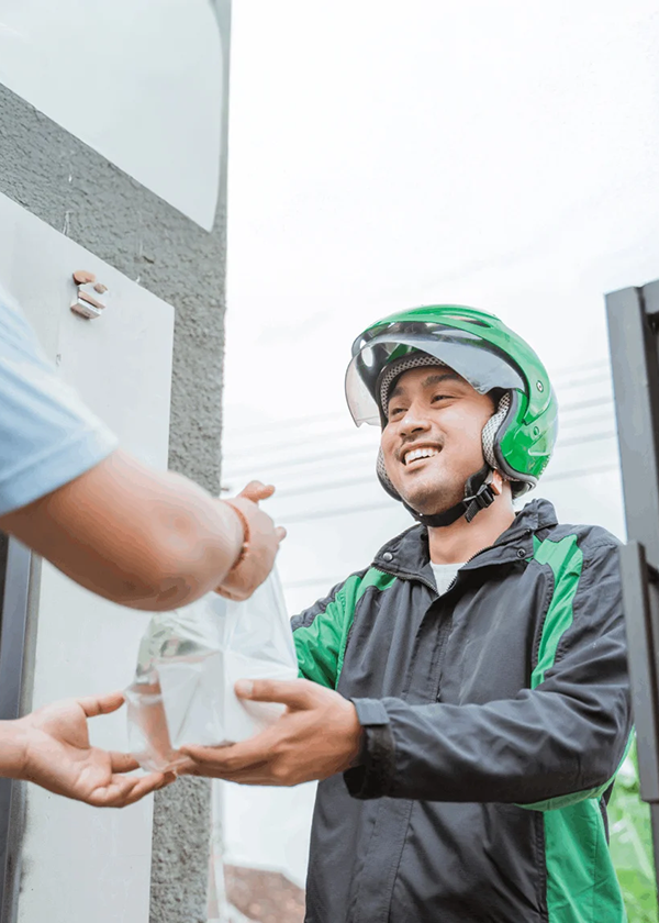Food delivery man with helmet passing bag