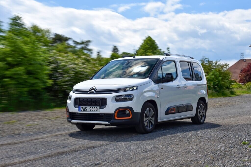 a white citroen berlingo van on the road on a sunny day