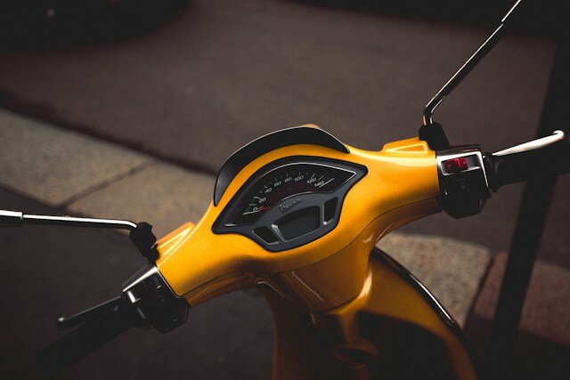 handlebars and dashboard of a yellow scooter