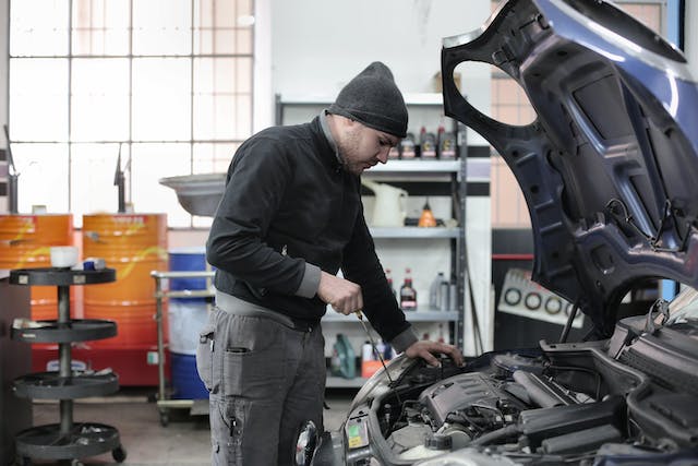 a mechanic checking the engine of a car