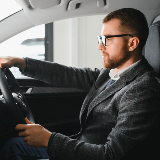 Man in a suit driving a car