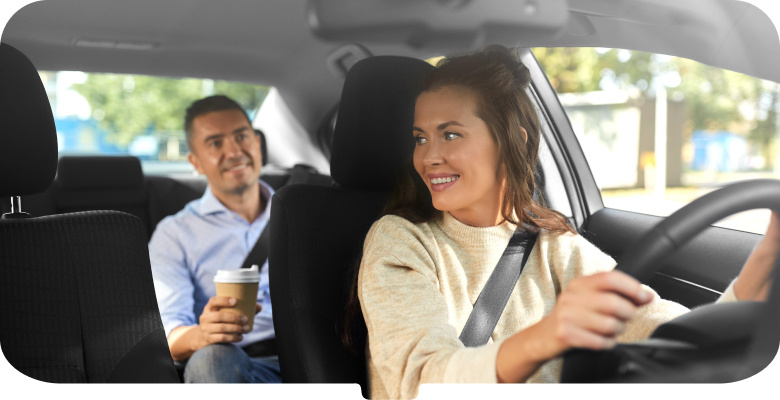 Woman driving car looking back at male passenger-mobile