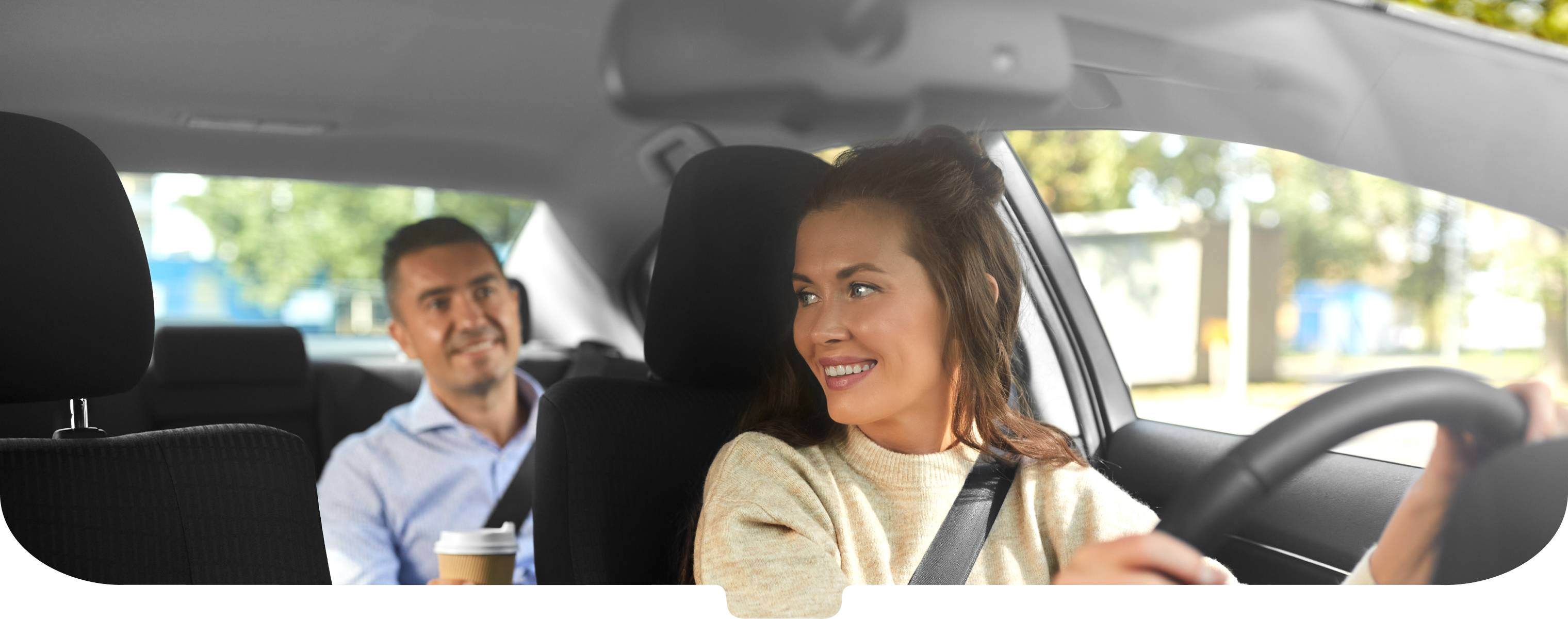 Woman driving car with man in back