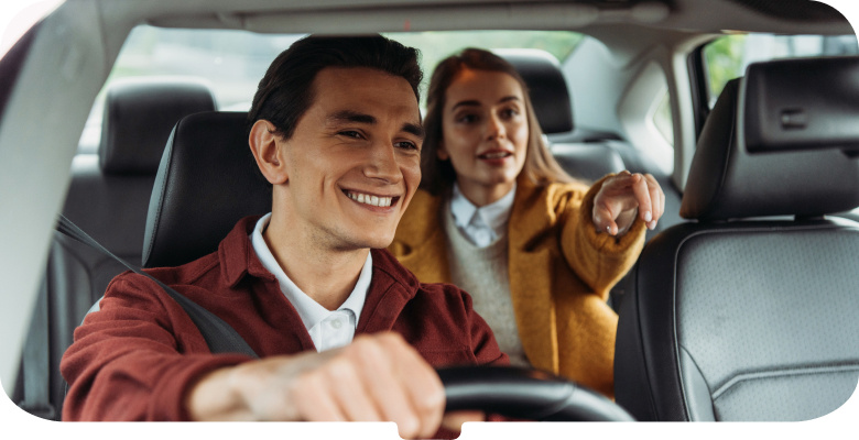 Smiling taxi driver in a burgundy jacket with passenger