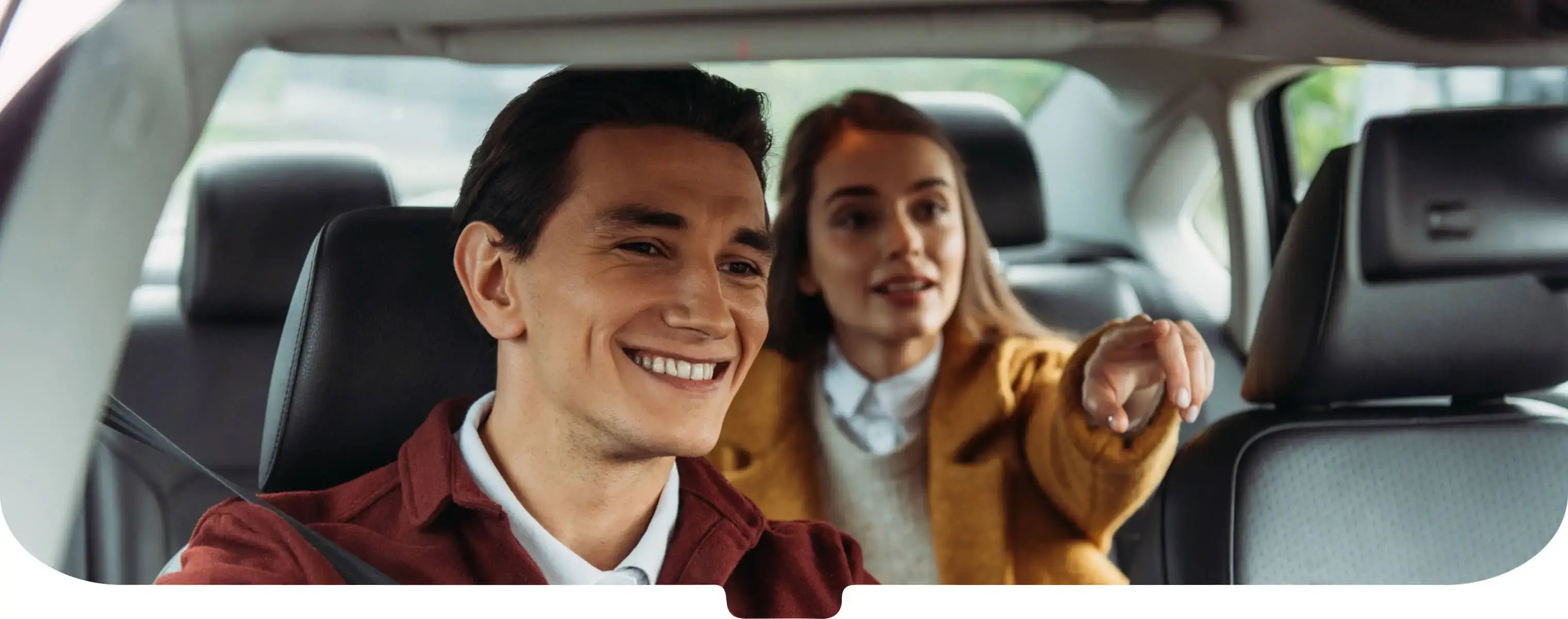 Smiling taxi driver in a burgundy jacket with passenger