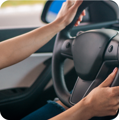 Close up of hands on steering wheel