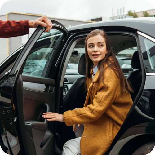 Woman in orange jacket getting out of car