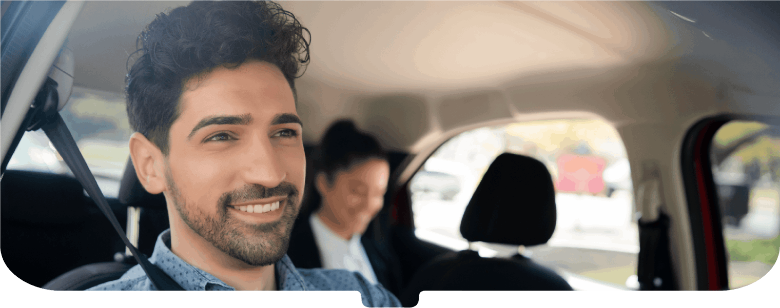 Smiling driver with a smartly dressed passenger on the backseat