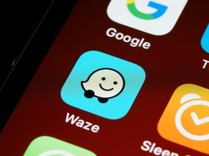 Blue waze app icon on a phone screen