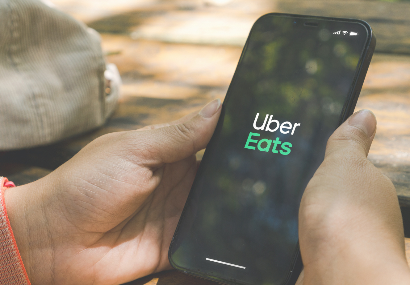 a person holding a phone with the Uber Eats logo shown on screen