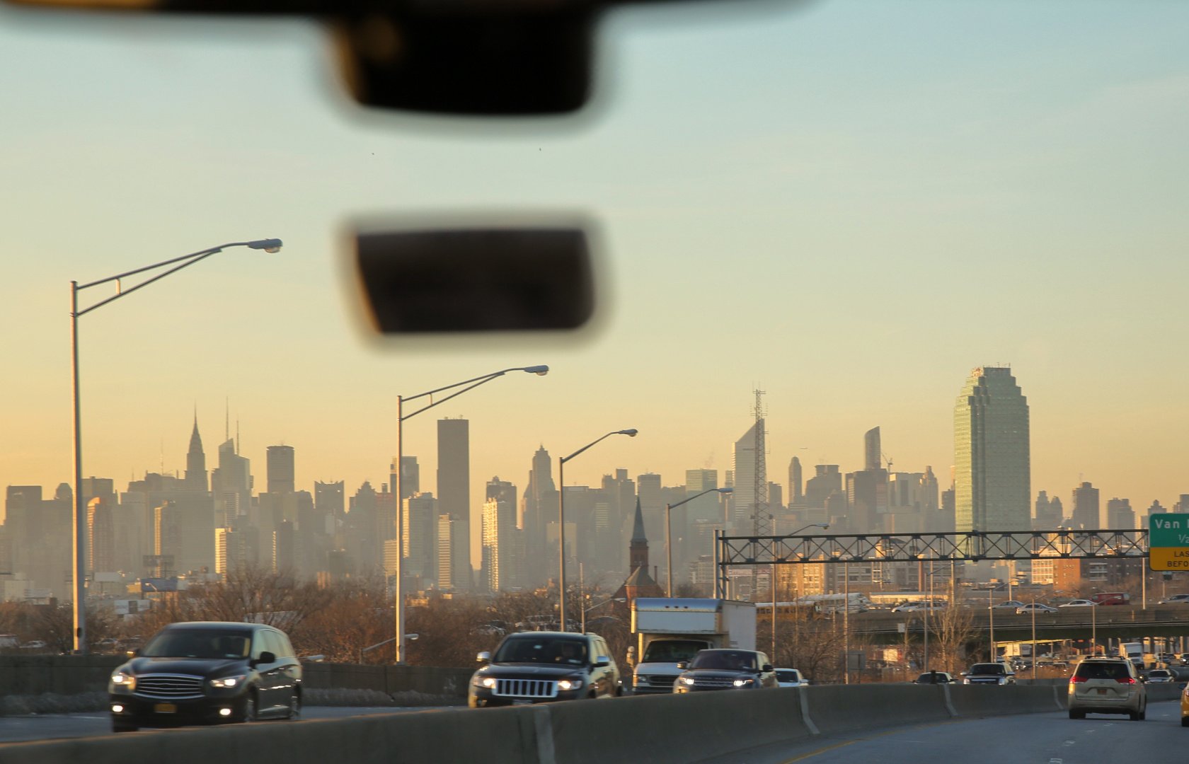 a view of new york city at dawn from the highway