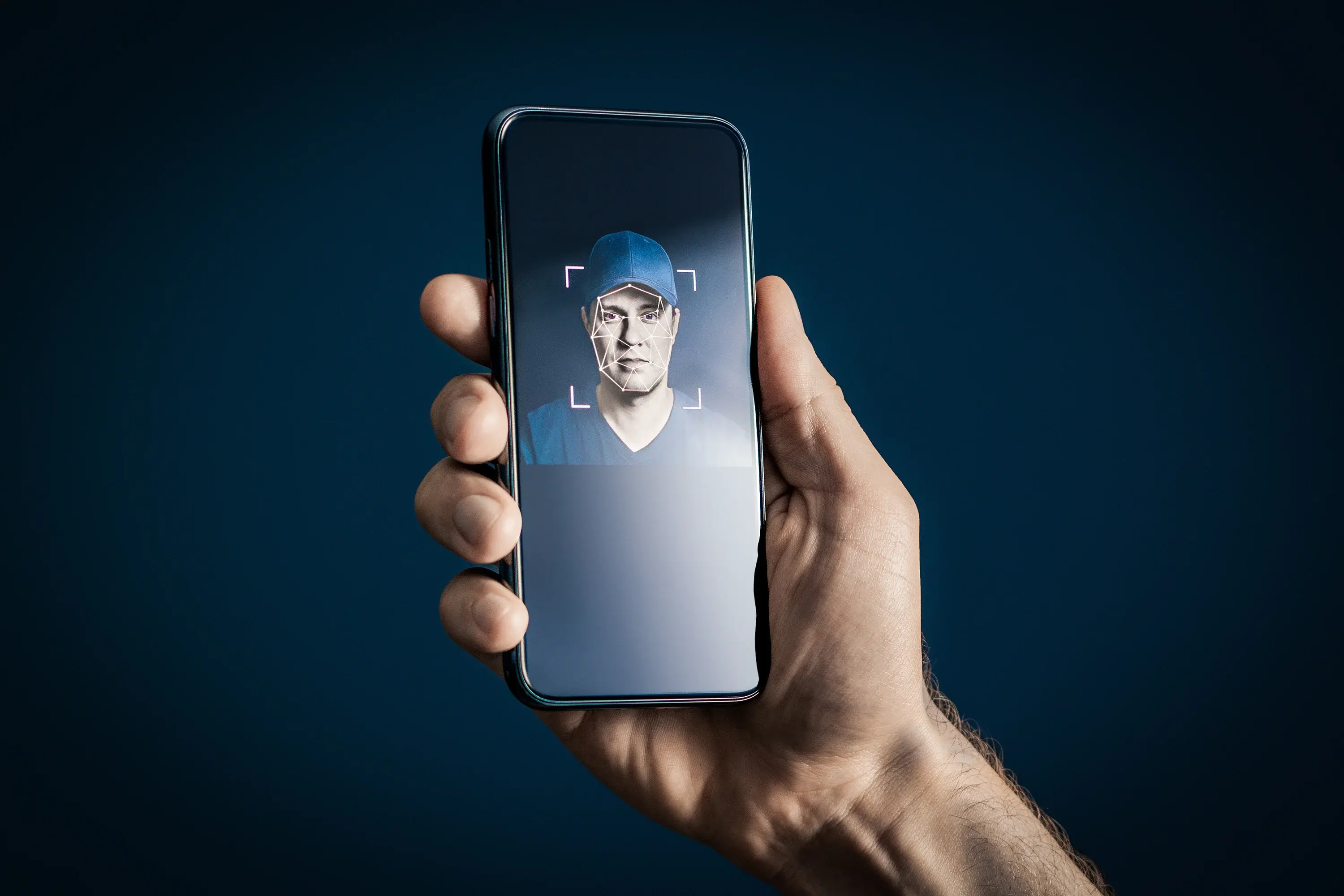 coourier Hand holding phone showing a driver having thier face scanned in a facial verification check