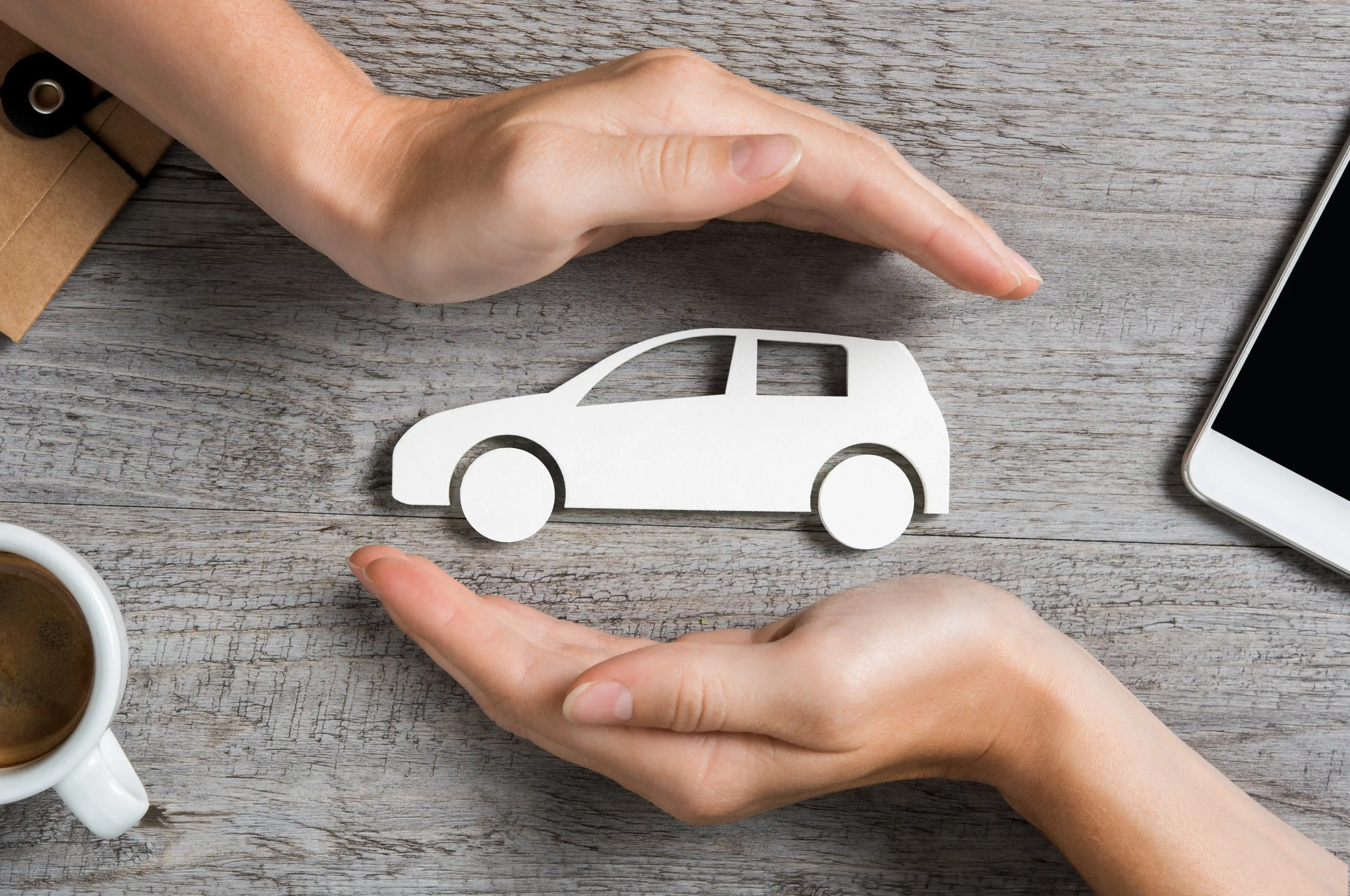 two hands protecting a car - for managing insurance renewal blog