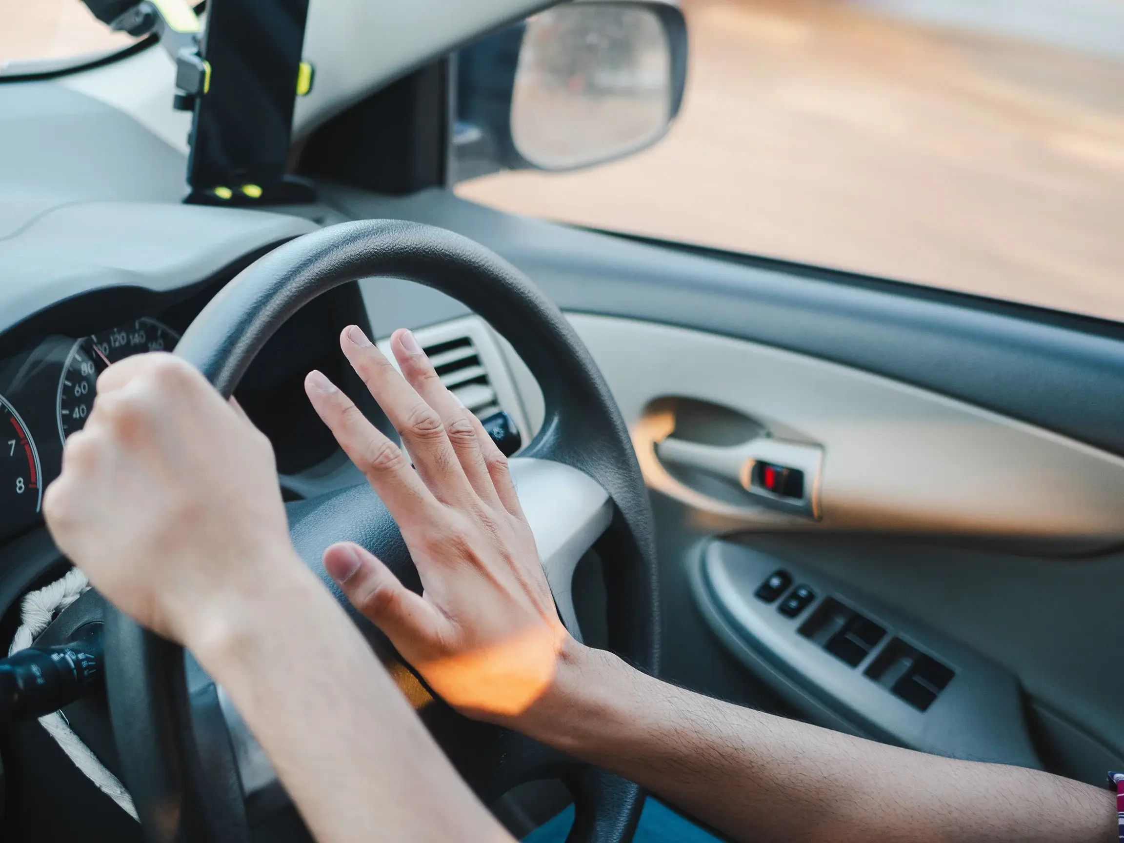 a person pressing their horn in a car