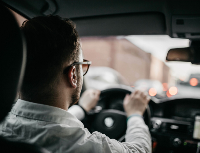 Back view of man in shirt driving car