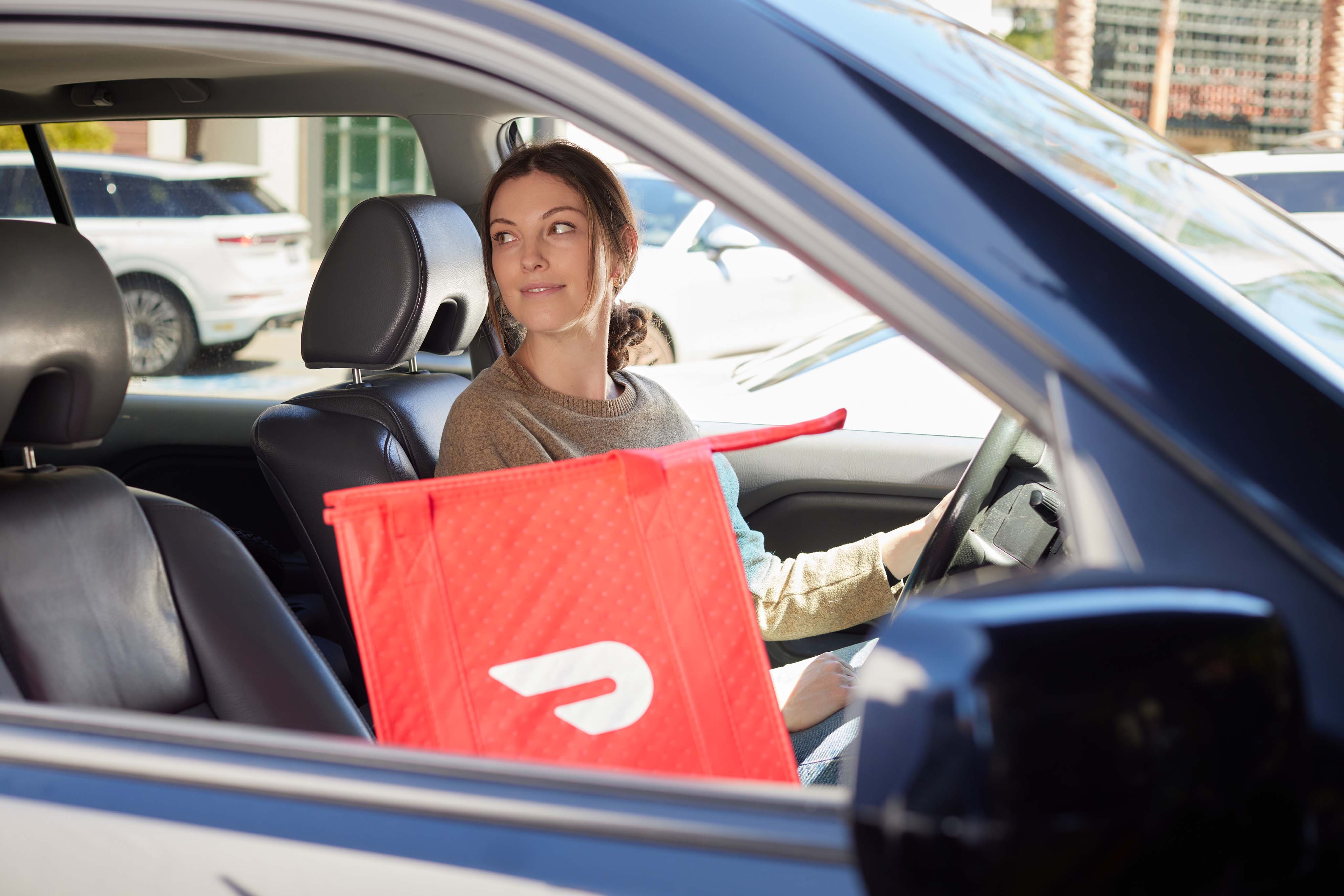 DoorDash delivery woman with food order in car