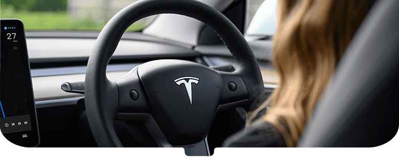 Woman driving a tesla in rear view mirror