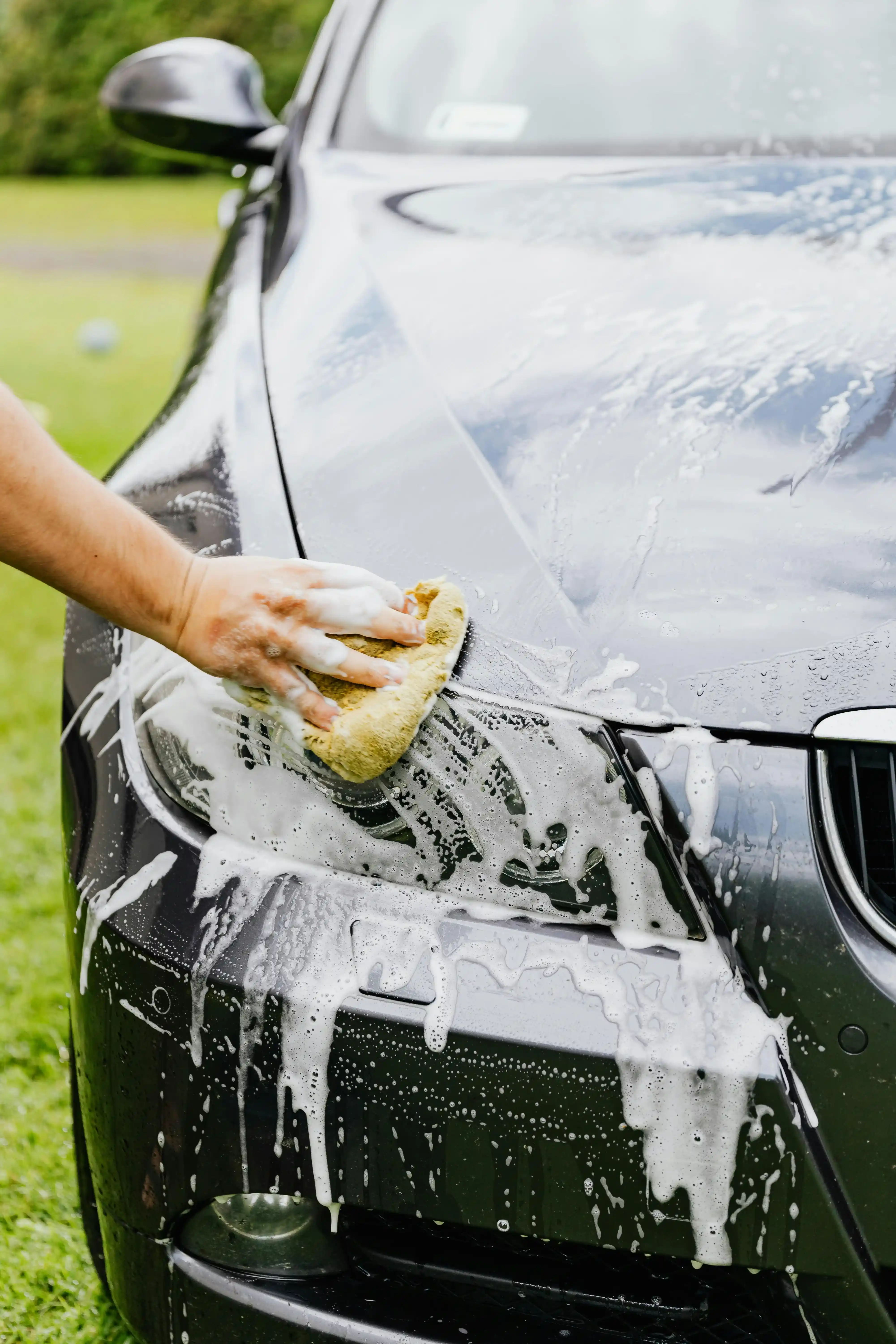 person washing their black car outside