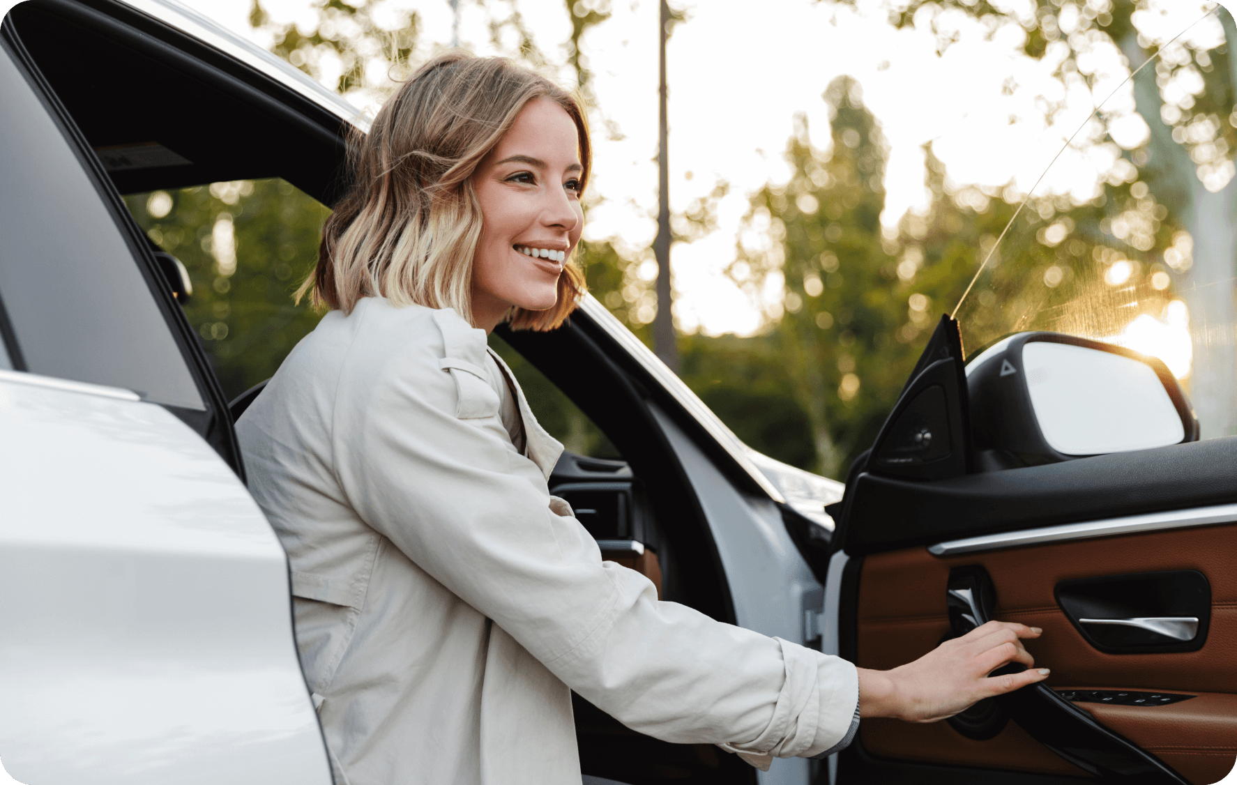 Woman in a smart, grey jacket stepping out of the driver's-side door of her car