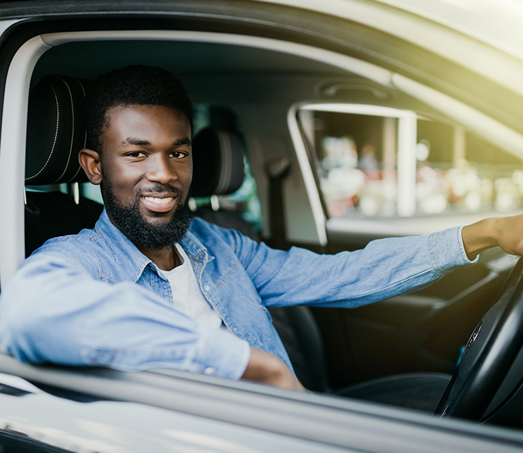 Smiling man leaning out of a car 