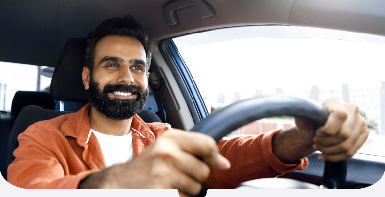 Bearded man in an orange jacket driving his car