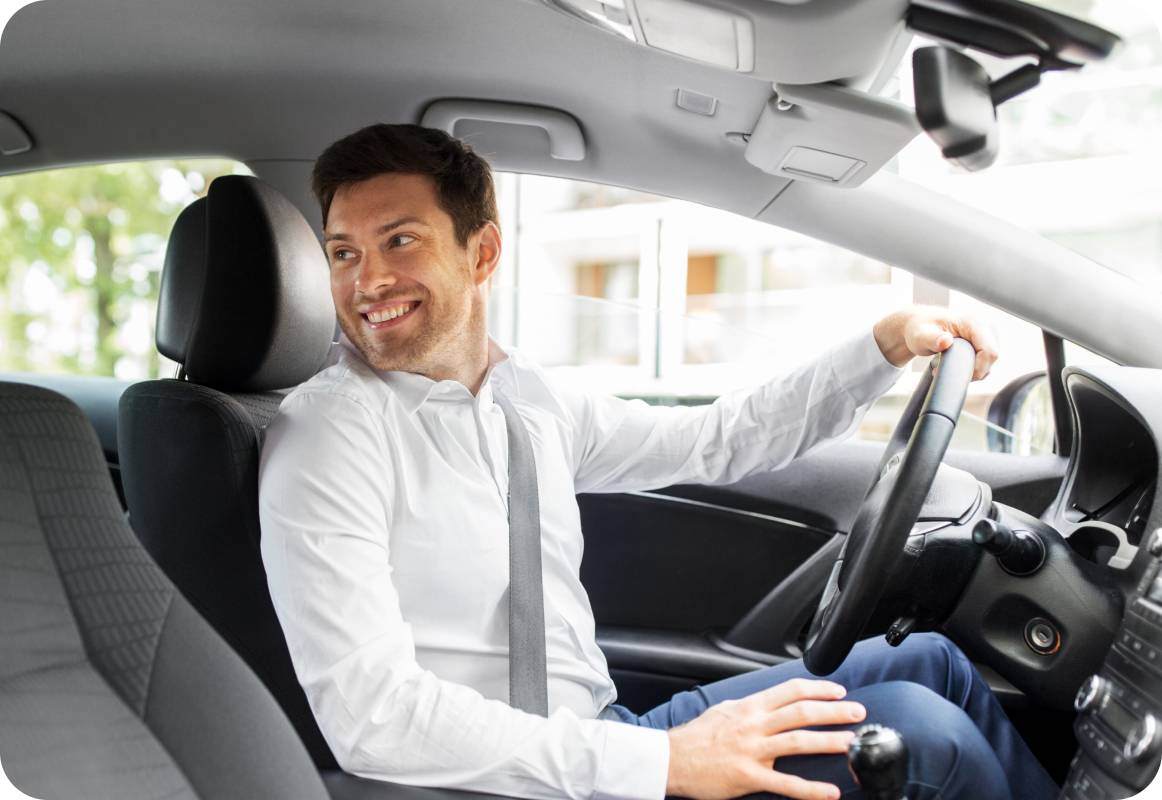 Taxi driver in car looking over his shoulder at his passenger