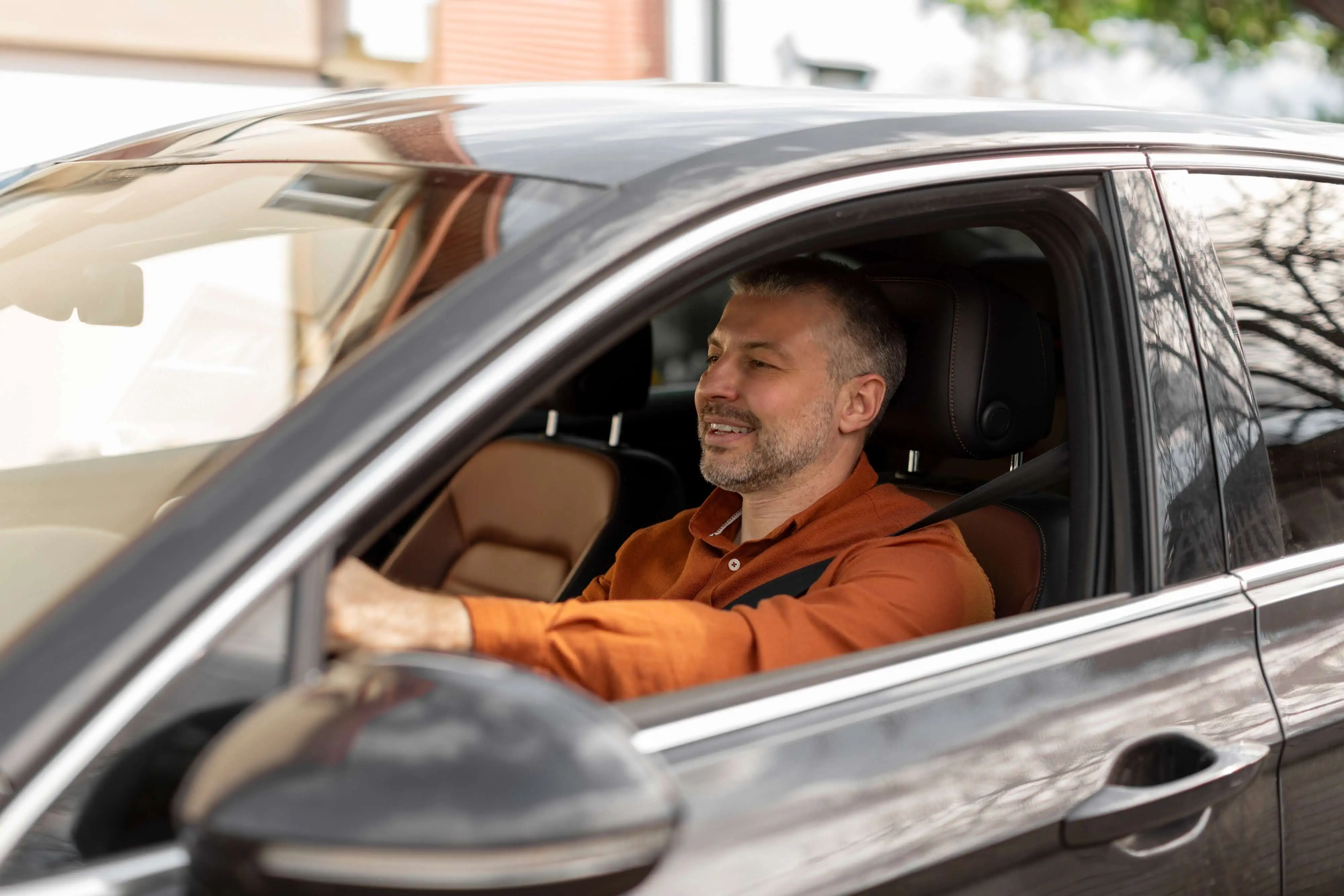 Taxi driver behind the wheel of a black car