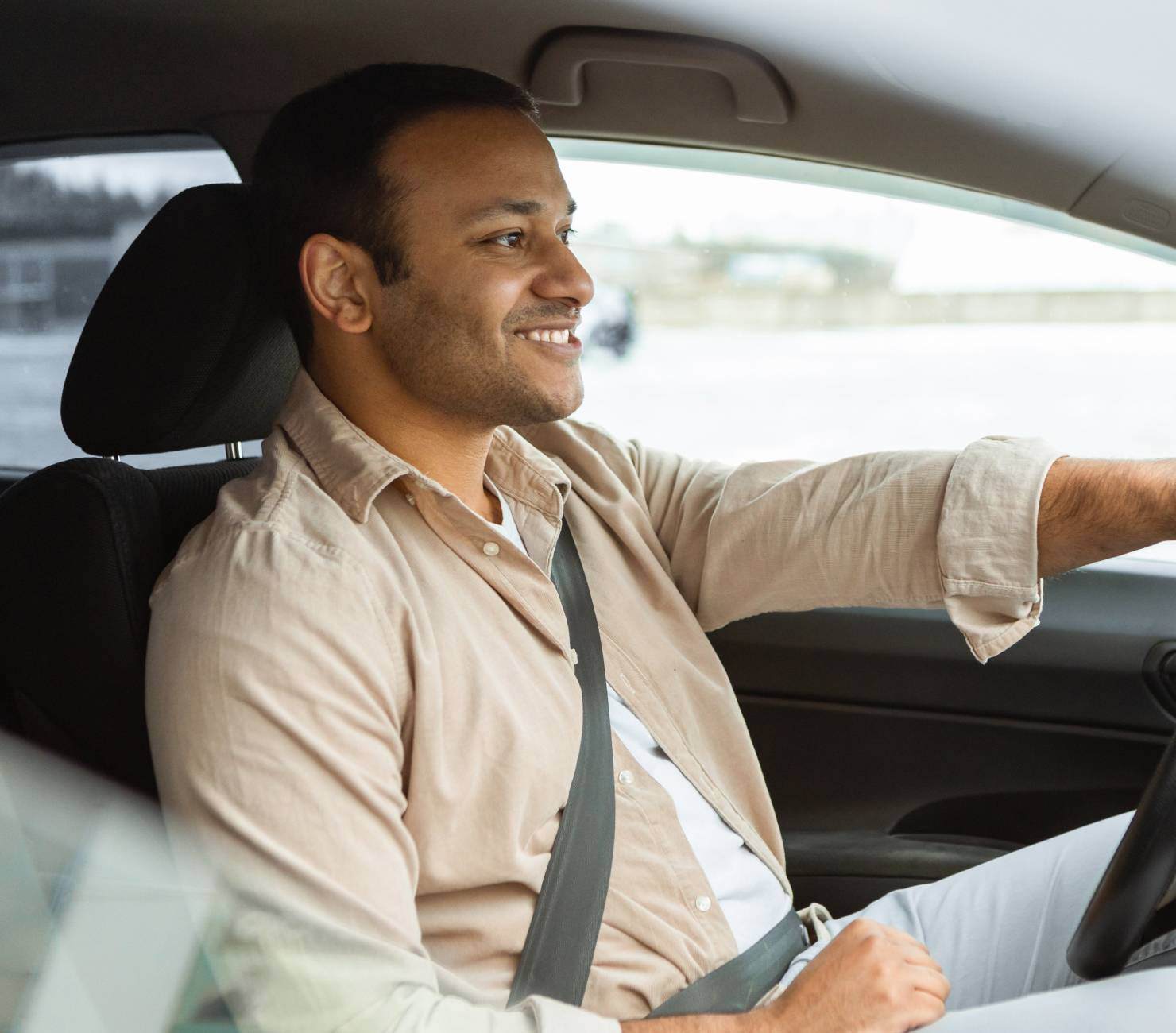 Side view of happy man driving car