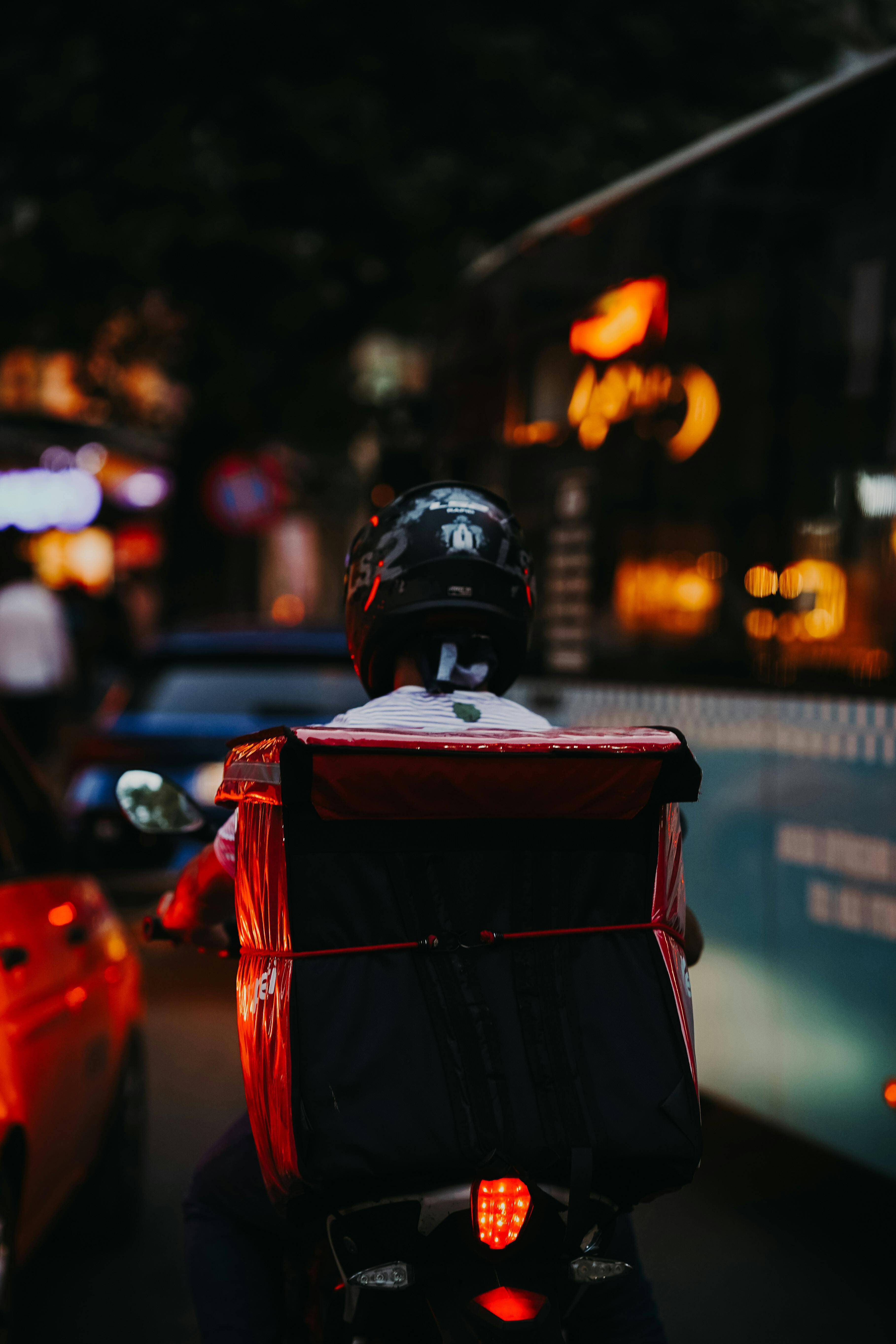 a delivery driver at night with their back to the camera