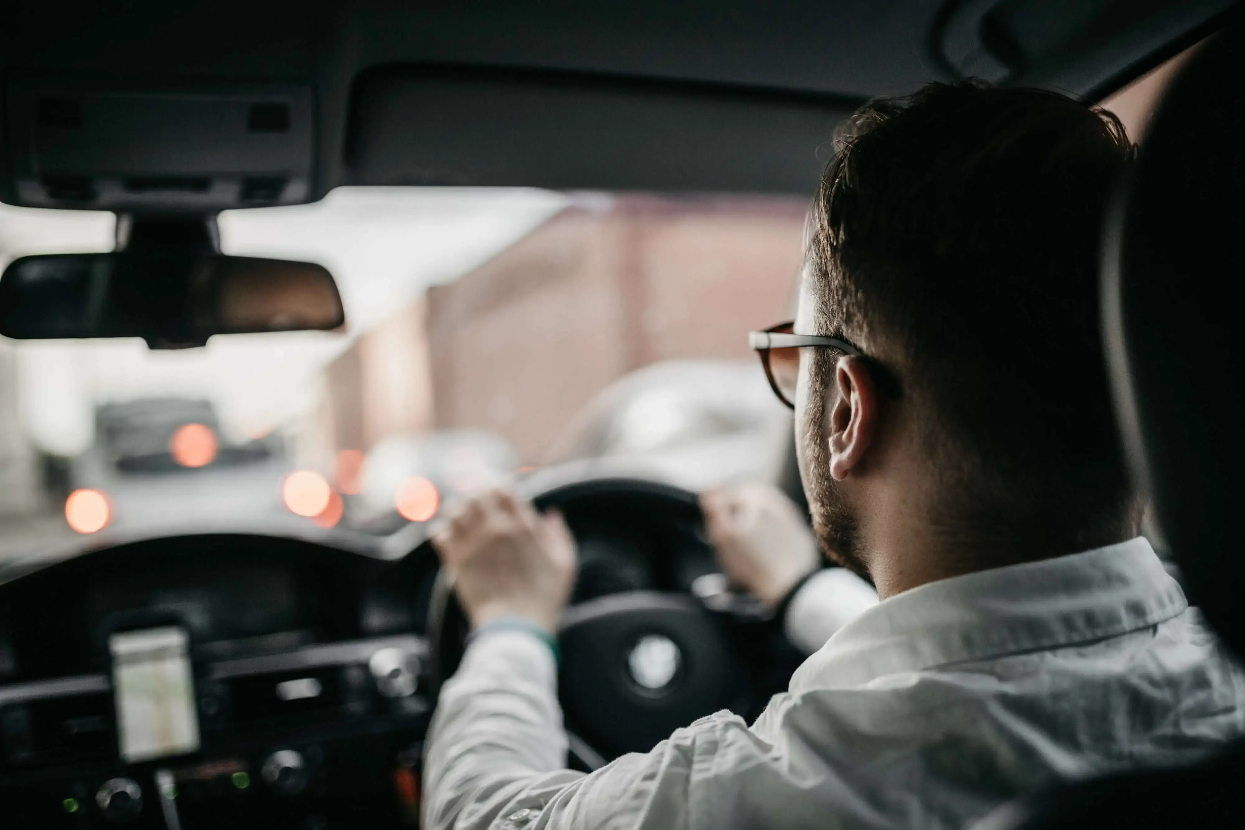 Driver in a white shirt and glasses