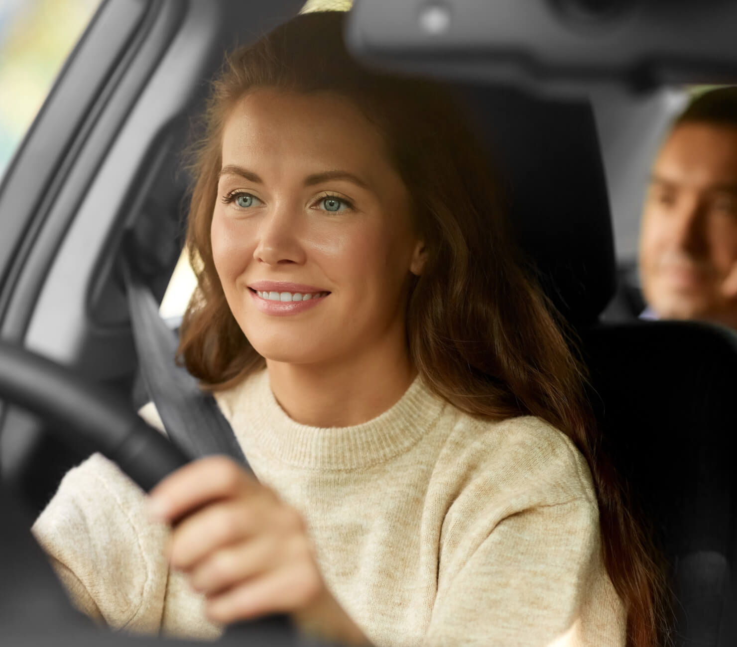 Women in cream jumper driving passenger