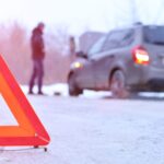 car repair on the road in winter. Car triangle on winter road. Problem with vehicle on snowy road. Broken cars concept. banner of snowy winter road.