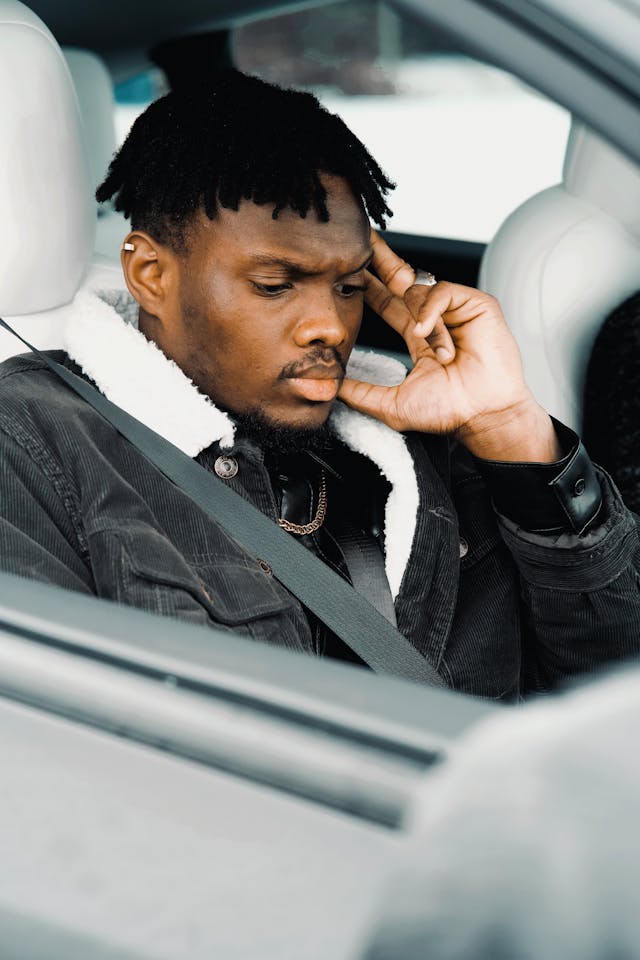 man in passenger seat of a car wearing a seatbelt
